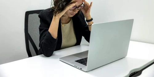 Poza de cover  Cand este momentul potrivit sa mergi la un psiholog Semne si indicii de luat in considerare O femeie la birou, laptop, dificultati psiho emotionale jpg