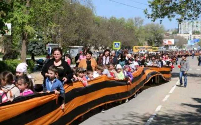 Chiar şi copiii din clasele primare sunt utilizaţi de îndoctrinaţii adulţi pentru a glorifica o ideologie criminală care a adus şi găgăuzilor, dar şi românilor dintre Prut şi Nistru, doar suferinţe. În imagine: "parada" din Vulcăneşti, 25 aprilie. FOTO: deschide.md