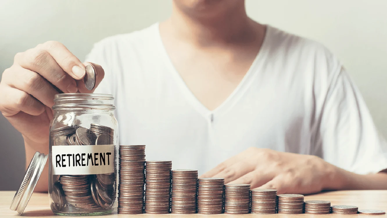 O femeie mută mai multe fișicuri de monede într-un borcan pe care scrie „retirement”