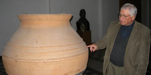 Istoricul Marius Constantinescu cu un vas găsit în pivniţe