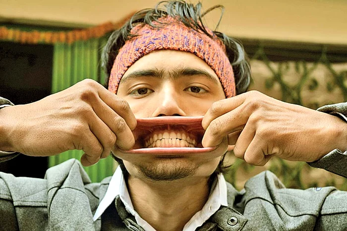 Tânărul nepalez cu gura de plastilină şi-a înfipt 32  de lumânări aprinse  în „vorbitoare”