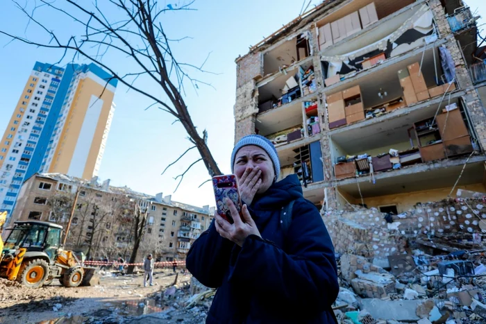 O femeie plânge în Kiev privind distrugerile cauzate de bombardamente. FOTO Profimedia