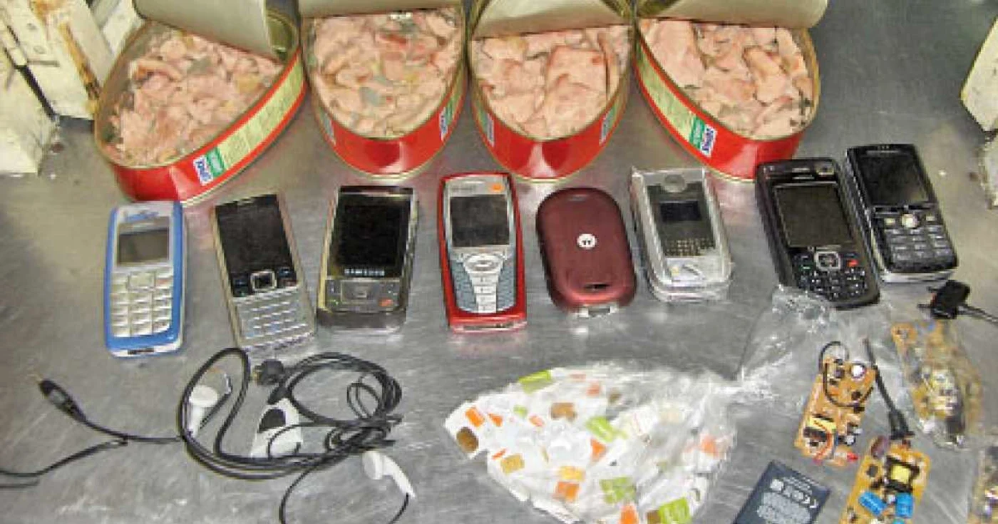 Celulare cu cartele sim şi căşti erau ascunse printre bucăţi de carne, în conserve.