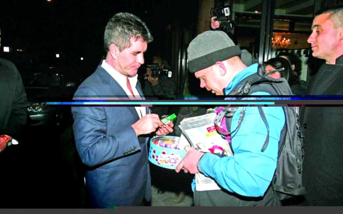 Prezentatorul TV Simon Cowell a primit o bomboană de la
cerşetorul d elux în schimbul unei „donaţii“ de 20 de lire

FOTO: Guliver Splash News