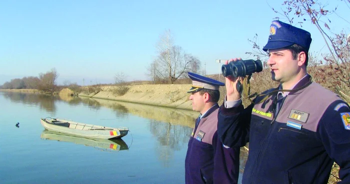 Poliţiştii de frontieră scrutează orizontul cu ajutorul binoclului