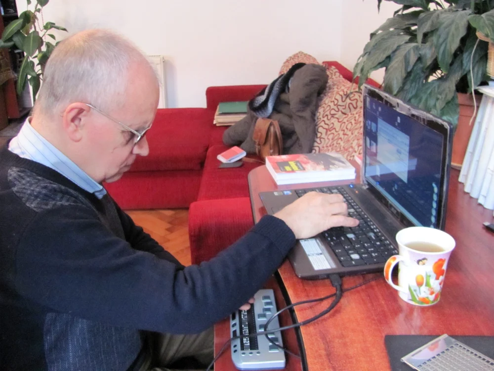 Vasile Adamescu petrece zilnic aproape cinci ore în faţa laptopului. Citeşte ştiri, răspunde la e-mailuri şi scrie cărţi pentru copii de la şcoala de nevăzători din Cluj-Napoca FOTO: Florina Pop