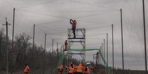 Muncitori ucraineni instalează plase anti-dronă în Harkov FOTO AFP