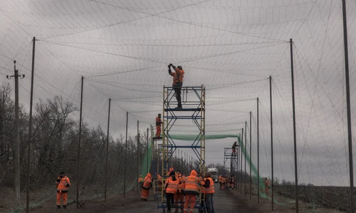 Muncitori ucraineni instalează plase anti-dronă în Harkov FOTO AFP