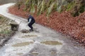 Localnicii care s au săturat să aştepte intervenţia autorităţilor pe un drum judeţean din Munţii Orăştiei au ieşit cu roaba şi lopata pentru a l repara jpeg