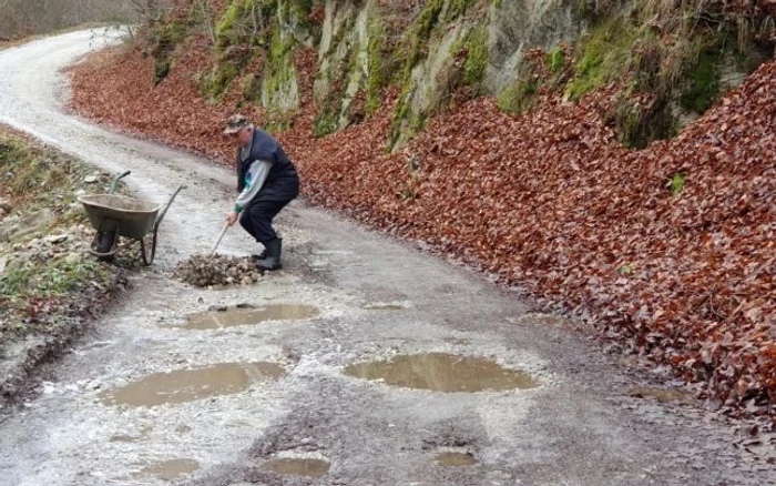 Localnicii care s-au săturat să aştepte intervenţia autorităţilor pe un drum judeţean din Munţii Orăştiei au ieşit cu roaba şi lopata pentru a-l repara