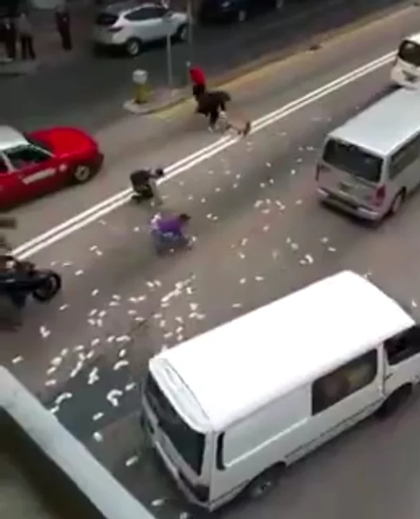 
    Banii s-au împrăştiat pe stradă, iar şoferii au oprit şi au adunat fiecare câteva bancnotecaptură video  