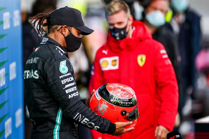 
    Lewis Hamilton privește casca oferită de Mick ShumacherFoto: Guliver / GettyImages  