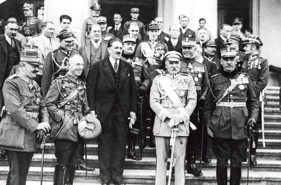 Mareșalul Piłsudski (în costum de culoare deschisă) pe treptele Muzeului Militar din București,  în timpul vizitei din 1928. E încadrat de generalul Angelescu,  ministrul român de Război (primul din dreapta) şi de Jan Szembek,  ambasadorul Poloniei la București (în costum); al doilea din stânga,  râzând,  e Ion Antonescu.