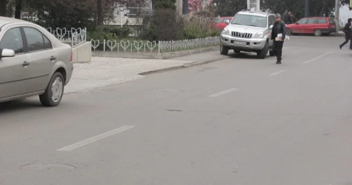 Pietonii sunt nevoiţi să ocolească pe stradă maşinile parcate pe trotuar FOTO