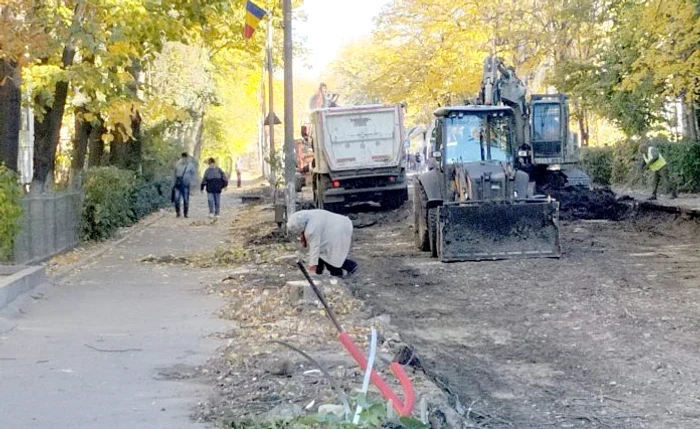 O bătrână îngenunchează pentru a putea ajunge în siguranță pe trotuar FOTO Vremea Nouă