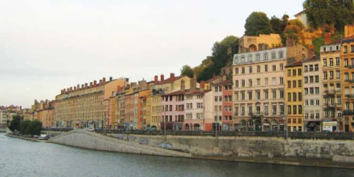 Clădirile vechi şi colorate din Lyon se reflectă în apele râului Rhône