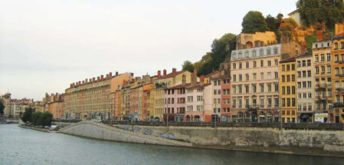 Clădirile vechi şi colorate din Lyon se reflectă în apele râului Rhône