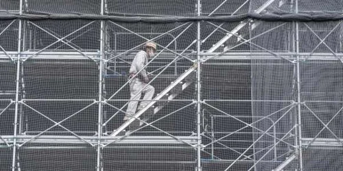 Un muncitor în construcţii urcă schele pe noul stadion naţional stadionul principal al Jocurilor Olimpice şi Paralimpice Tokyo 2020 în Tokyo Japonia FOTO Guliver / Getty Images / Carl Court  