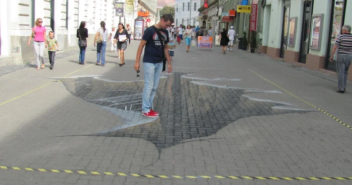 Alex Nedelcu în faţa craterului 3D de pe strada Alba Iulia