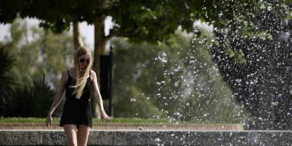 O fată se răcoreşte într-o fântână arteziană dintr-un parc de lângă Templul lui Debod din Madrid Spania din cauza valului de caniculă accentuată care traversează peninsula FOTO AFP / Javier Soriano