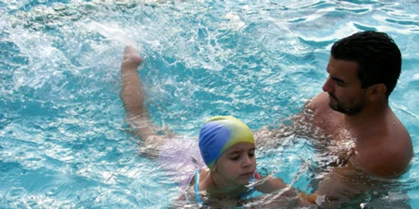 O fetiţă este deprinsă cu apa de un instructor profesionist