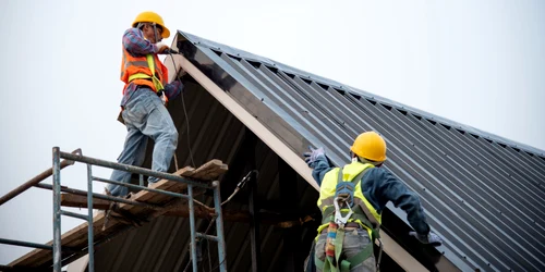Muncitori lucreaza la acoperisul unei case FOTO Shutterstock