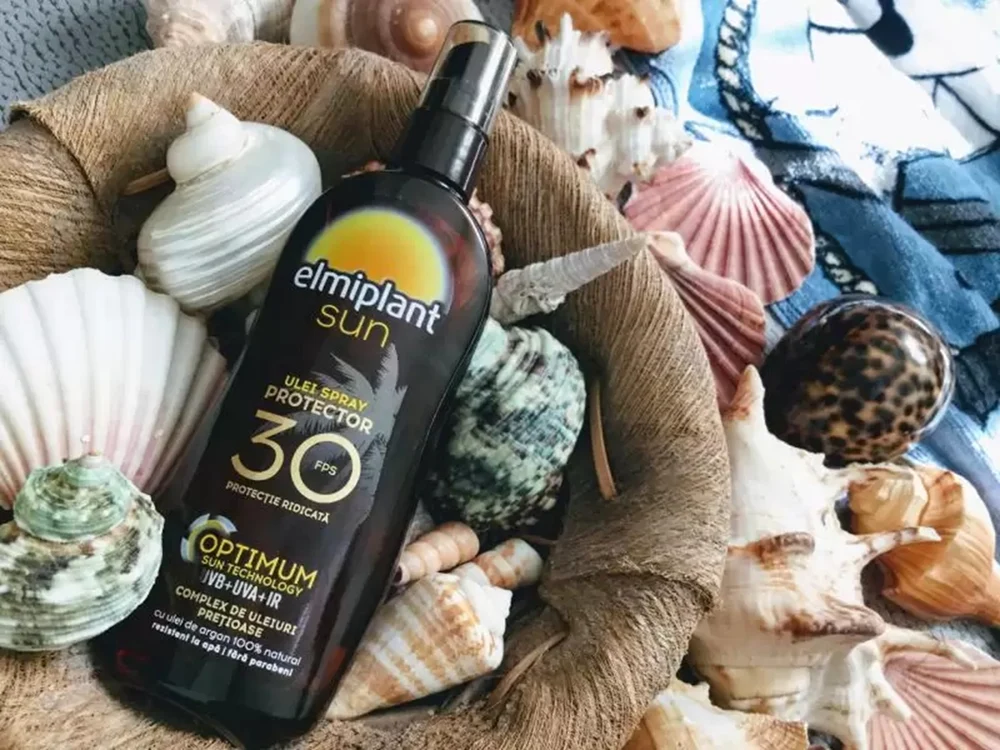 Prezentare ulei autobronzant cu protecție solară Elmiplant Sun SPF 30 printre scoici F: Dark Passion