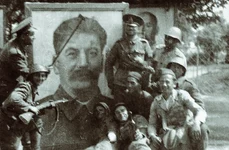 Soldați români la Tiraspol, în fața unui portret supradimensionat al lui Stalin