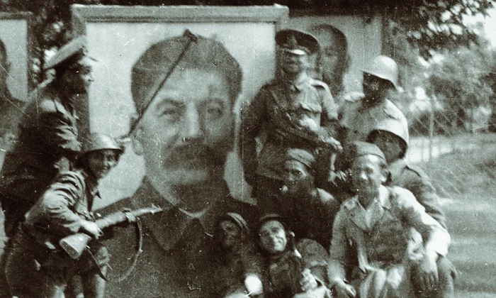 Soldați români la Tiraspol, în fața unui portret supradimensionat al lui Stalin