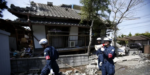 Poliţişti strigă după oamenii care ar putea fi prinşi sub dărâmături lângă o casa lovită de cutremur în Mashiki prefectura Kumamoto sudul Japoniei FOTO AP