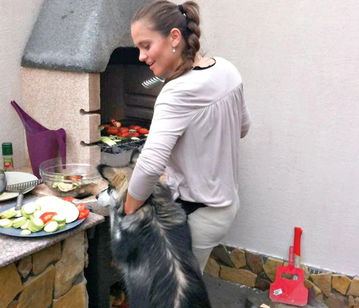 Căţelul se întinde  spre farfurii, să adulmece  legumele, dar Cristina  îl opreşte la timp