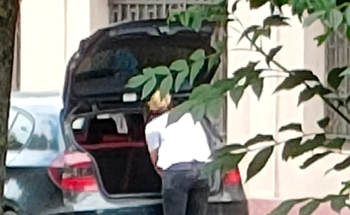 După ce smulge florile, femeia le pune în autoturismul său. Foto: Facebook/ Poliția Locală