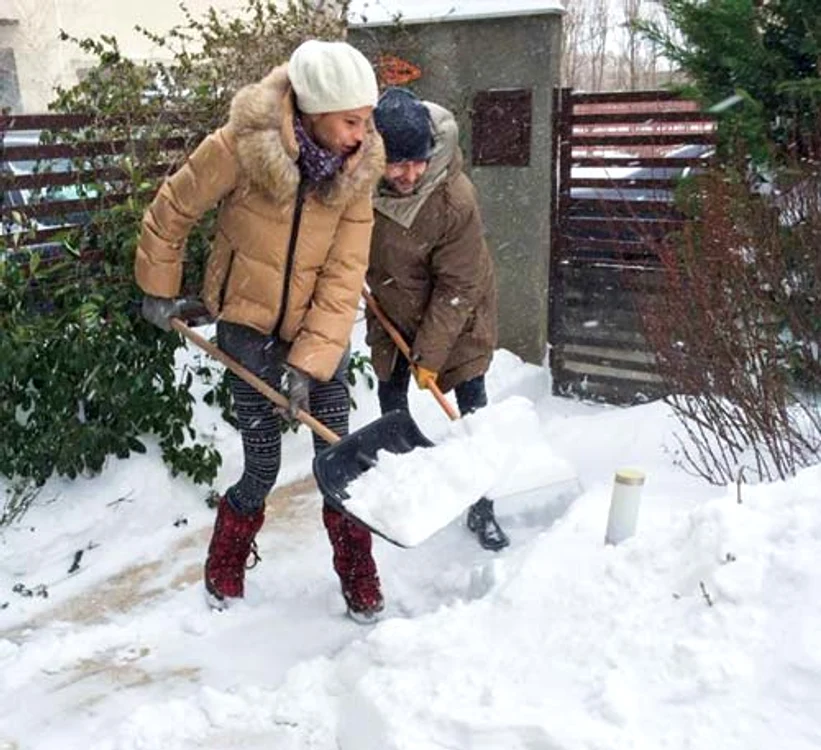 Adi Sînă și Anca Serea  curăță împreună zăpada din curte