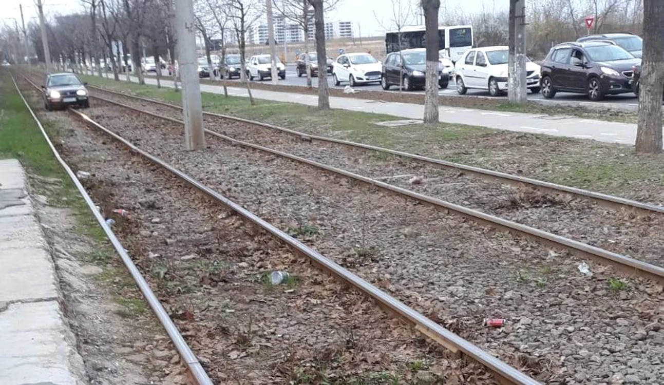 
    Ca să nu stea la coadă, șoferul din imagine și-a chinuit mașina pe ditamai șinele de tramvai Fotografii: Click!  