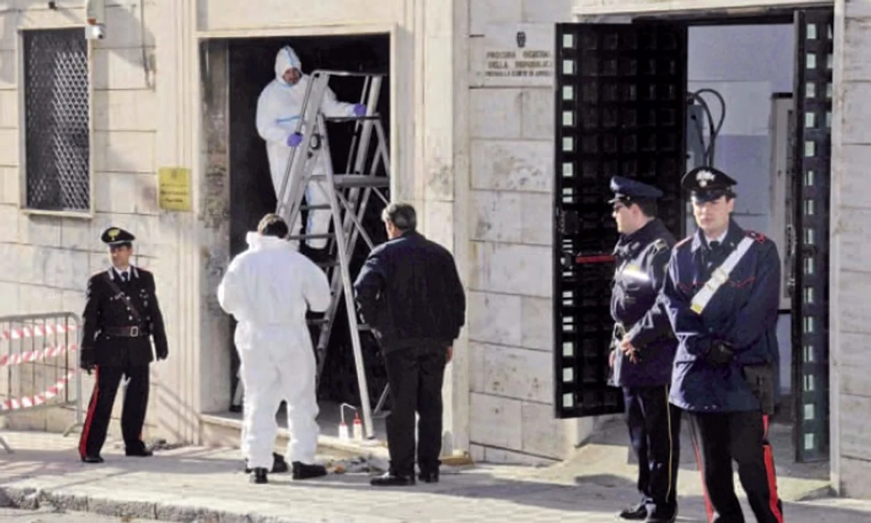 Scene obişnuite în sudul Italiei: carabinierii inspectează intrarea într-un tribunal din Reggio Calabria,  parţial distrusă de o explozie cu bombă; principalii suspecţi erau membri ai ’Ndrangheta,  care ar fi încercat astfel să intimideze procurorii (2010)