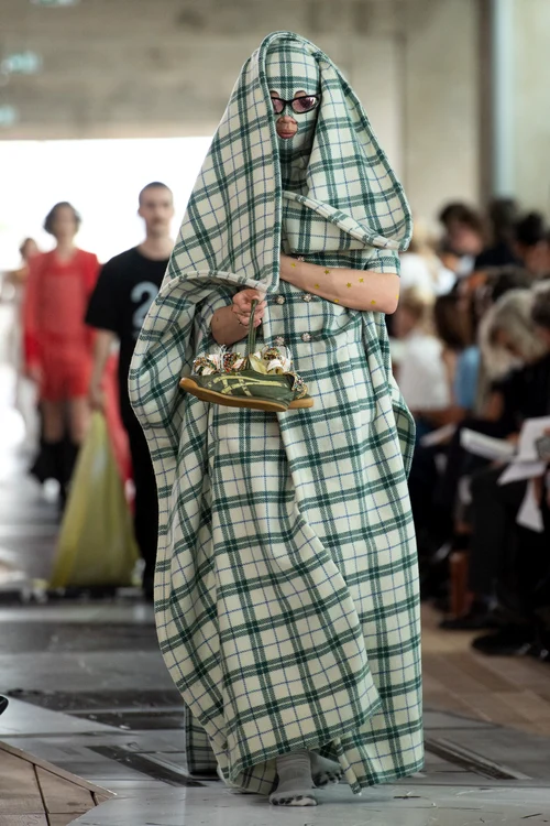 Model acoperit complet, îmbrăcat într-o tinuta verde, la Saptamana Modei de la Paris