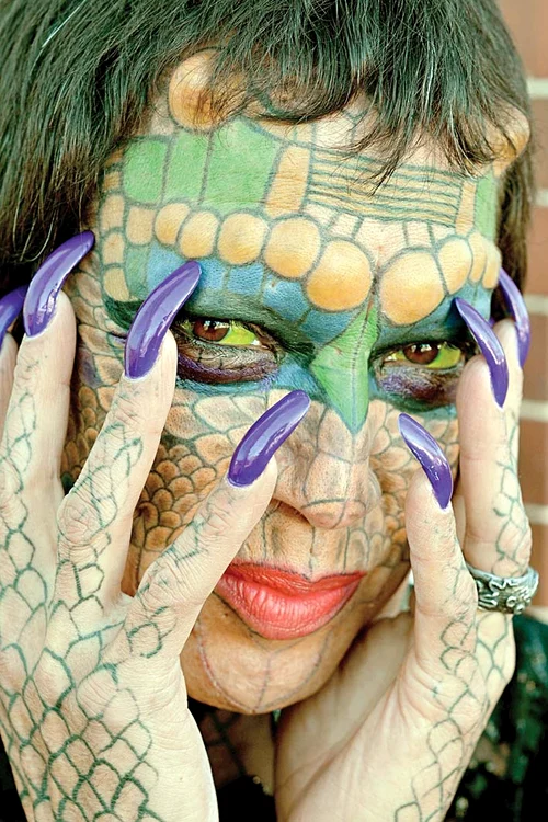 1991 - Îşi pune coarne, îşi tatuează solzi şi îşi schimbă sexul