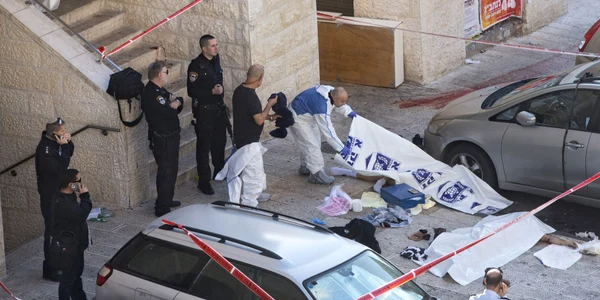 Un expert criminalist israelian acoperă corpurile a doi palestinieni la locul unui atac într-o sinagogă din Ierusalim FOTO AP