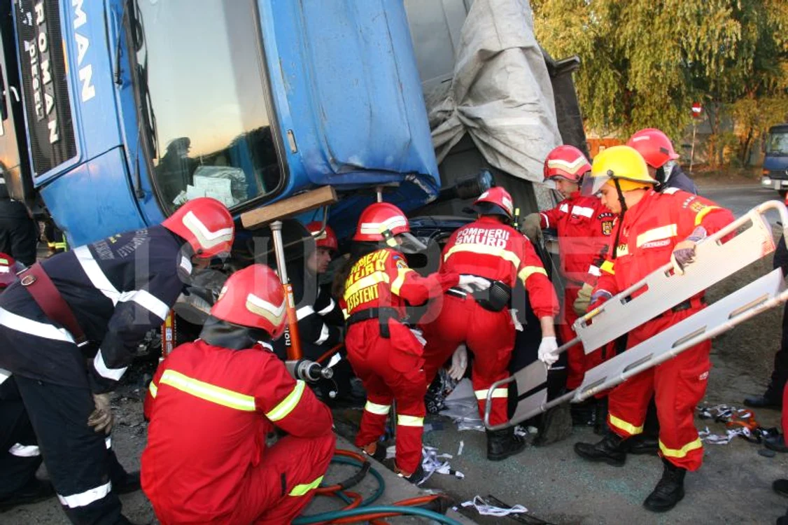 
    Basculanta s-a răsturnat pe o parte peste autoturismul în care se aflau patru persoane Foto: ISU Bucureşti  