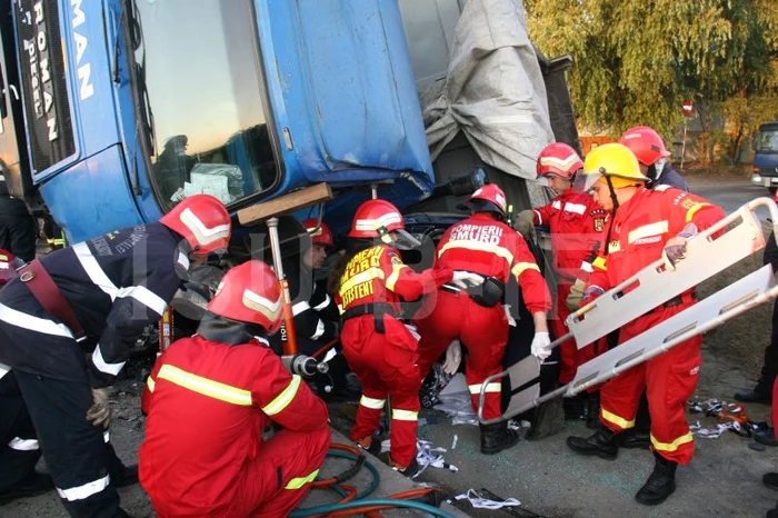 Basculanta s-a răsturnat pe o parte peste autoturismul în care se aflau patru persoane Foto: ISU Bucureşti