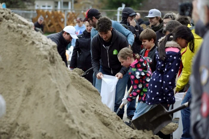 Justin Trudeau ajută la ridicarea unui dig la Terrasse-Vaudreuil FOTO Twitter @JustinTrudeau