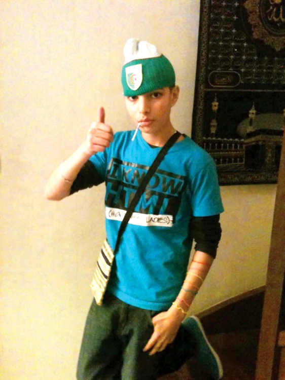 
    2011. Adel Kermiche (14 ani) se poza pe internet cu o căciulă algeriană  