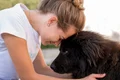 side view woman with fluffy black dog outdoors jpg