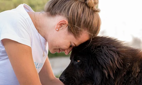 side view woman with fluffy black dog outdoors jpg