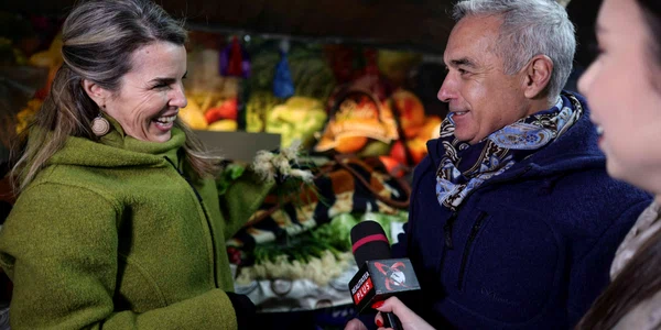 Călin Georgescu, însoțit de soția Cristela Georgescu, personal de pază și reprezentanți ai unui post de televiziune, face cumpărături în Piața 16 Februarie, în București. FOTO Inquam Photos / Octav Ganea