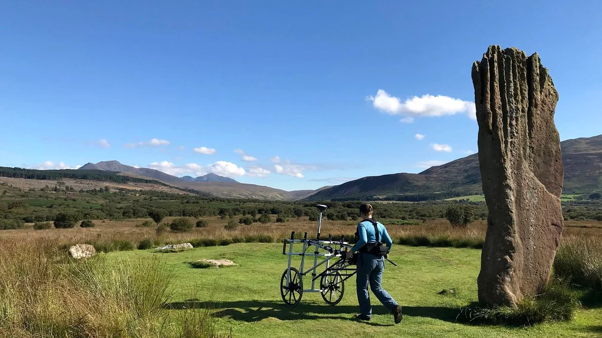 Un cercetător folosește echipament pentru a detecta anomalii sub turbă la Machrie Moor (© Historic Environment Scotland)