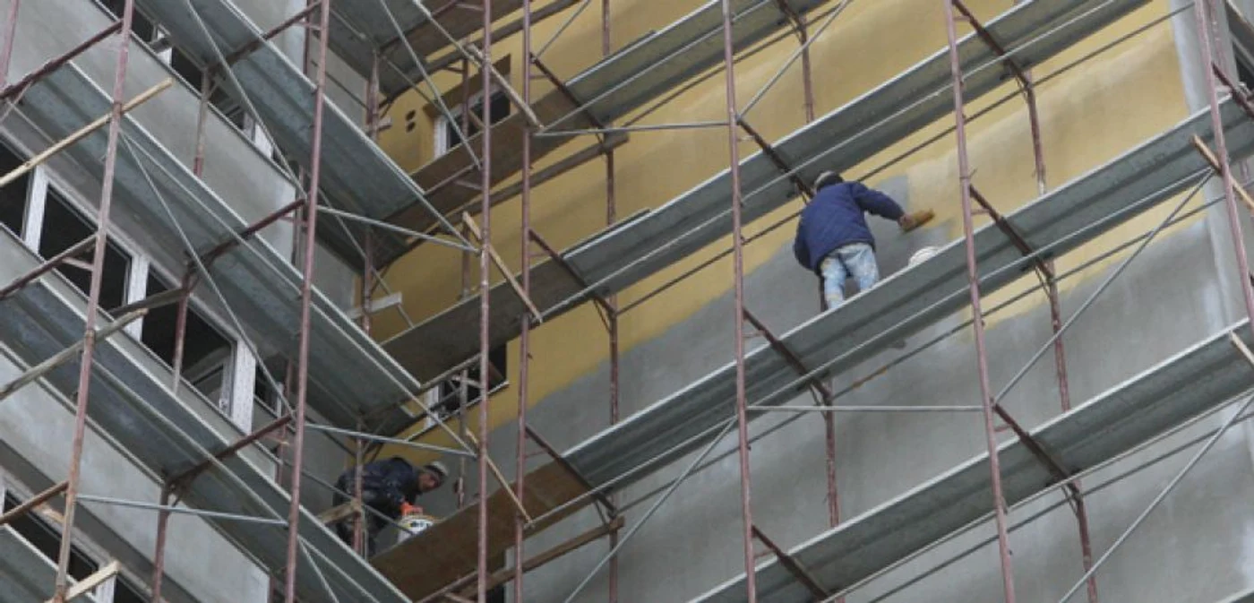 Muncitorii care izolează blocul nu poartă echipament de protecţie