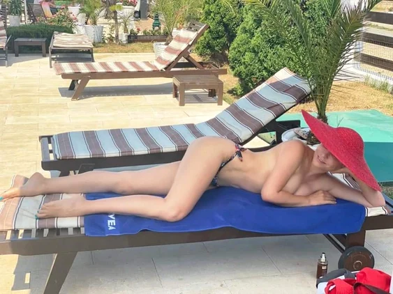 Adina Buzatu, tolănită pe șezlong, în curtea hotelului din Vama Veche