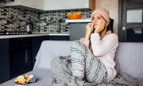 young woman home clothes sitting sofa use spray nose jpg