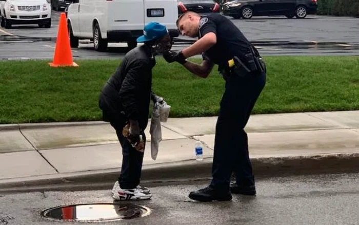 Un poliţist ajută un om al străzii să se bărbierească, foto Facebook